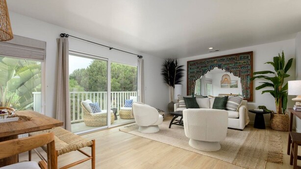 A spacious living room with a balcony, a dining area, and a seating arrangement. - Group-Friendly | Tranquil Oasis (Summerland)