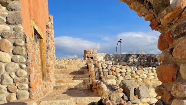 Una escalera de piedra que lleva a un edificio con una puerta de madera.