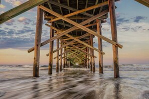 A wooden pier structure extending into the ocean with a clear sky in the background. - Multi-Family Gem! Heated Pool + Private In-Law Suite (Ocean Isle Beach)