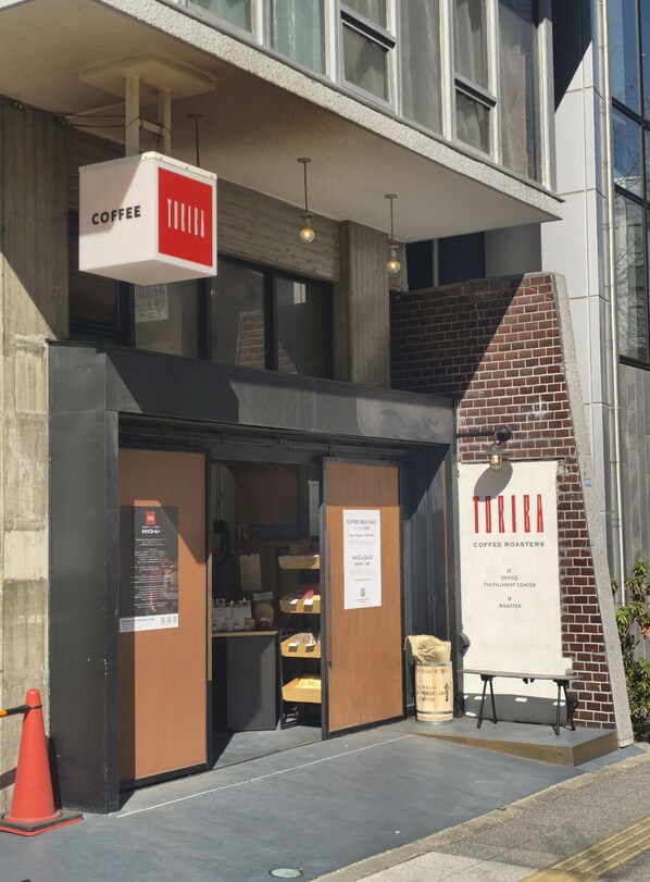 Un café dont l’enseigne porte les mots « CAFÉ » et « TIRIBA, TORRÉFACTEURS DE CAFÉ ».