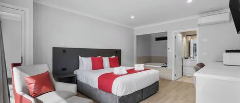 Una habitación de hotel moderna con una cama, un escritorio y una silla.