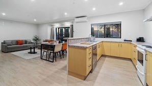A modern kitchen with wooden cabinets, a built-in oven, and a large window. - STAY280 & STAY284 Rotorua (Rotorua)