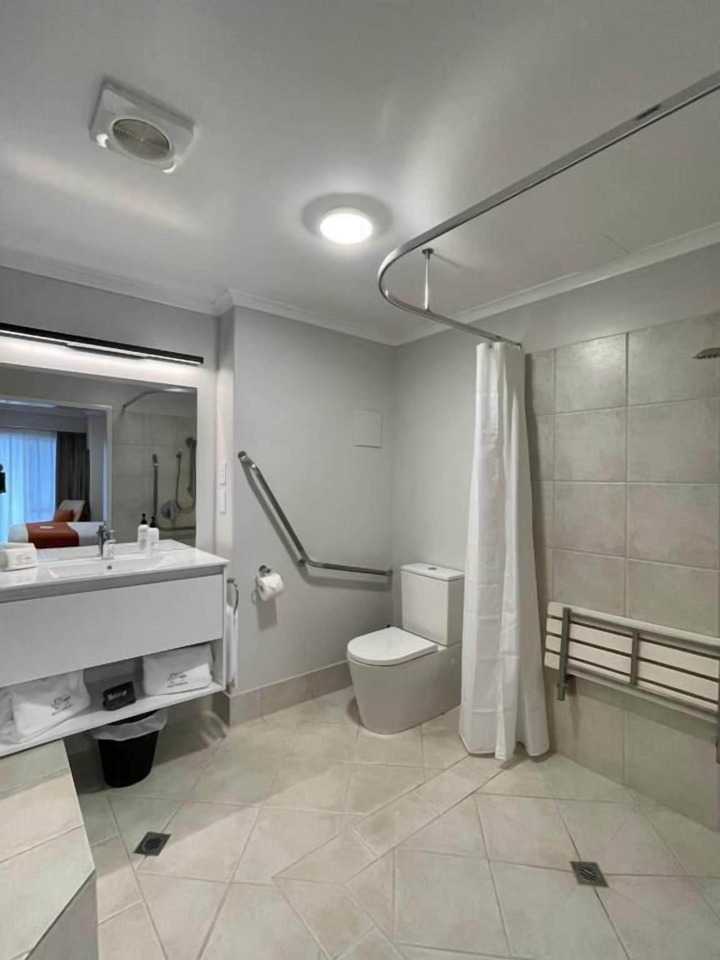 A modern bathroom with a shower, toilet, and vanity.