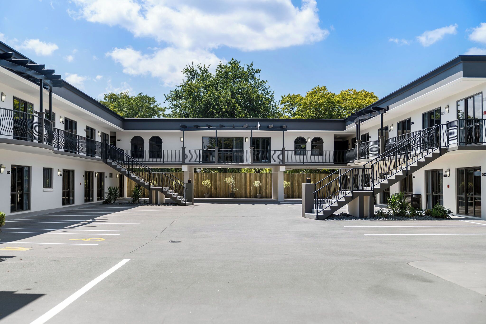 Un edificio moderno con un cortile centrale, due scale e un ingresso coperto.