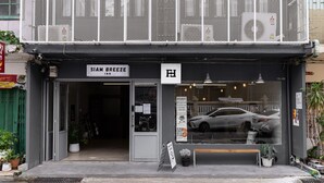 A storefront with a sign reading "SIAM BREEZE IN" and a large window displaying a car. - Siam Breeze Inn - Self Check-in (Bangkok)