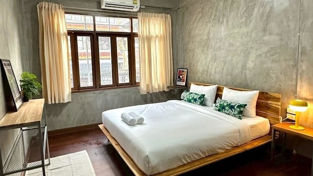 A modern bedroom with a large bed, a desk, and a window with curtains. - Siam Breeze Inn - Self Check-in (Bangkok)