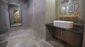 A bathroom with a white sink, a round mirror, and a shower area. - Siam Breeze Inn - Self Check-in (Bangkok)