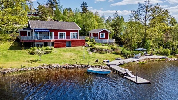 A lakeside cabin with a dock, a boat, and a well-maintained lawn. - Lake House Retreat with a Dock & Boat (Västra Götalands län)