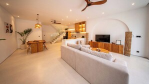 Un salon moderne avec un canapé, un téléviseur et des meubles en bois.