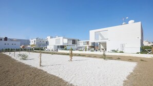 A modern building with a flat roof, large windows, and a white exterior.