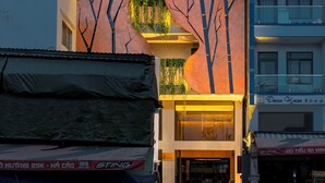 Un hôtel doté d'une grande enseigne au néon sur laquelle on peut lire « PYINT HOTEL » et qui se distingue par un élément architectural original en forme de feuille.