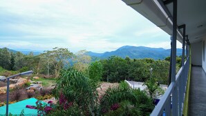A balcony with a view of mountains and greenery. - BlueHill Lotus Holistic Wellness Village (Sirumalai)