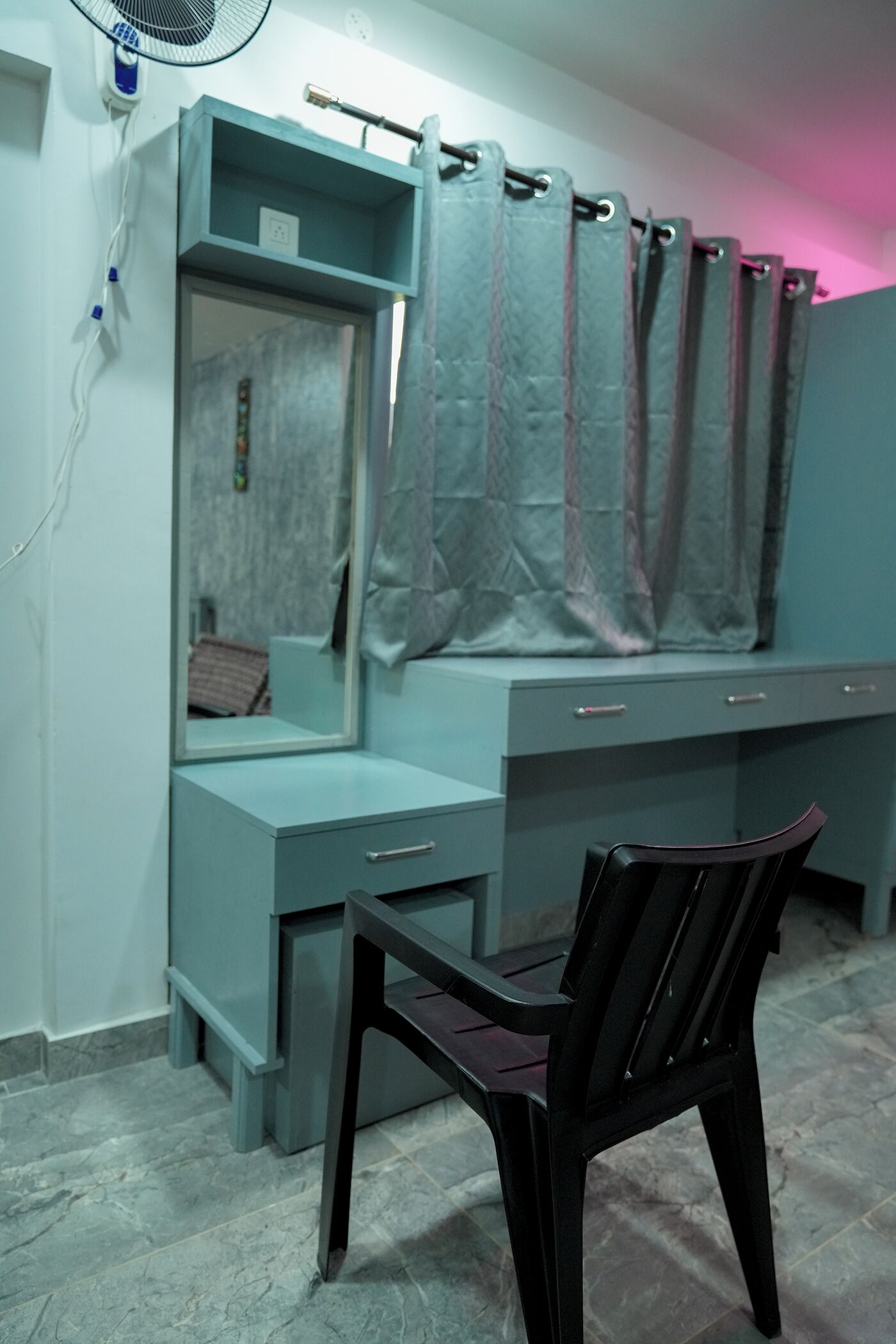 Une pièce comprenant un bureau, une chaise et un miroir.