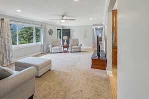 Relax in this inviting living room with a high ceiling, large window, and comfortable seating area.