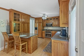 Enjoy cooking in this well-equipped kitchen with a central island, stainless steel appliances, and ample counter space.