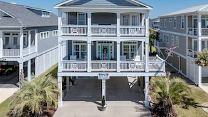 Un immeuble à plusieurs étages doté de balcons, d’une galerie couverte et d’une enseigne sur laquelle on peut lire : « Vue imprenable sur la mer ».
