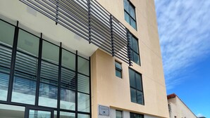 A modern building with large windows, a metal staircase, and a sign indicating it is a hotel.