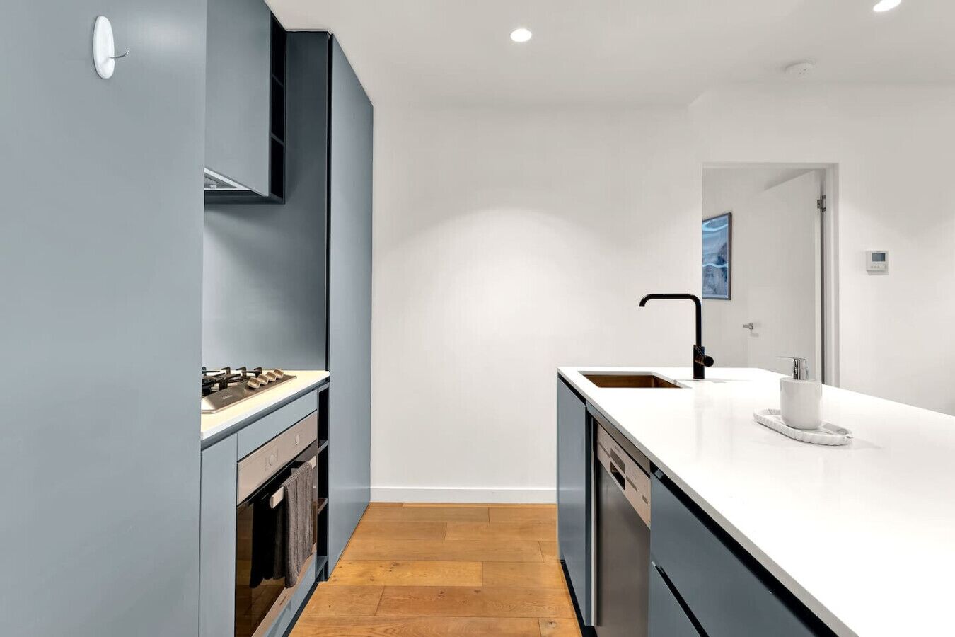 A modern kitchen with a built-in stove, a sink, and a dishwasher.