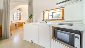 Et moderne køkken med indbygget mikroovn, vask og et vindue over bordpladen.