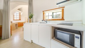 Una cocina moderna con microondas integrado, un lavamanos y una ventana sobre la encimera.
