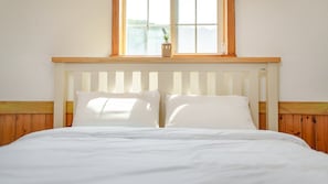 A bed with white bedding, a wooden headboard, and a window above. - Daebudo Sketch Pension (Ansan)