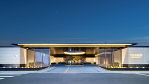 A modern hotel entrance with a spacious driveway, large glass doors, and a well-lit facade. - ningbo narada estate (Ningbo)