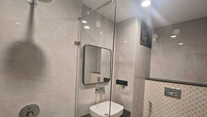 Un bagno moderno con cabina doccia in vetro, lavandino bianco e specchio.