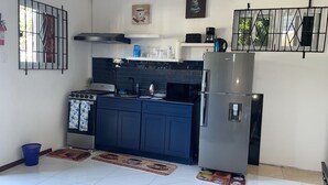 Une cuisine compacte équipée d’une cuisinière, d’un four, d’un four à micro-ondes et d’un réfrigérateur.