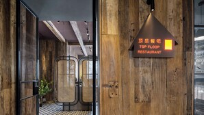 A wooden interior with a sign for 'Top Floor Restaurant'.