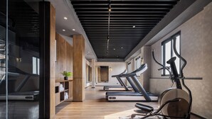 A modern gym with treadmills, an elliptical, and wooden accents.