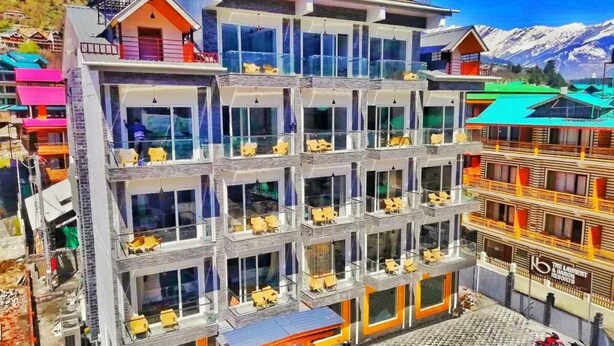 A multi-story hotel with balconies and outdoor seating areas. - Zen Zone The Laurent and Banon  (Manali)