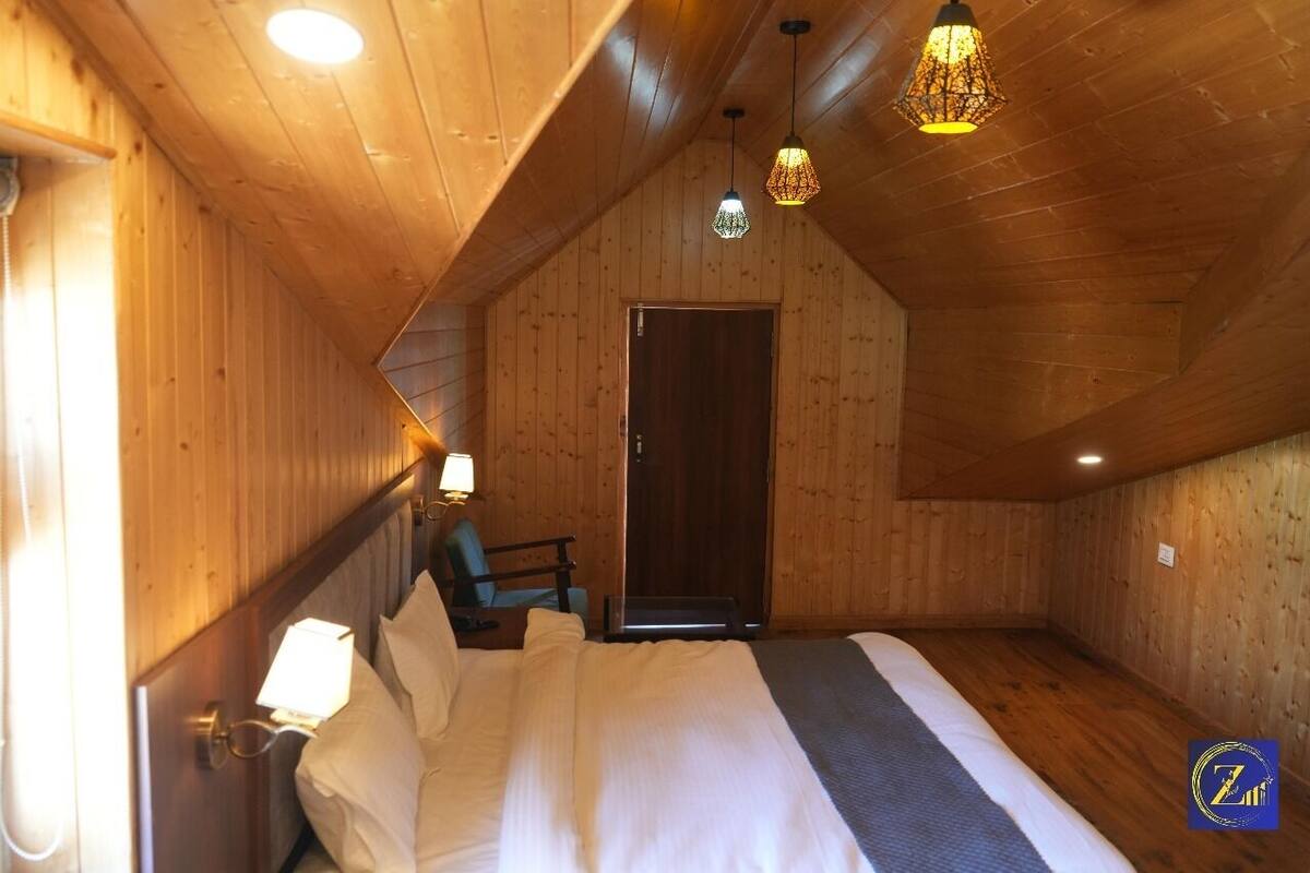 A wooden-paneled room with a bed, a chair, and a door.