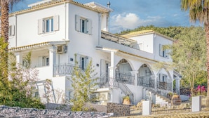 A two-story white building with balconies, a staircase, and a garden area. - Villa K Hotel (Corfu)