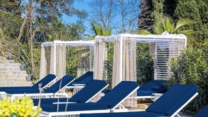 A poolside area with lounge chairs and a pergola structure. - Villa K Hotel (Corfu)