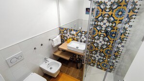A bathroom with a shower, a sink, a bidet, and a toilet. - New Suite with modern living room in central area. (Roma)
