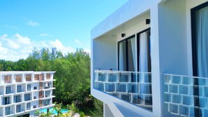 Un hotel modern amb diverses plantes, grans finestres i una zona de piscina.