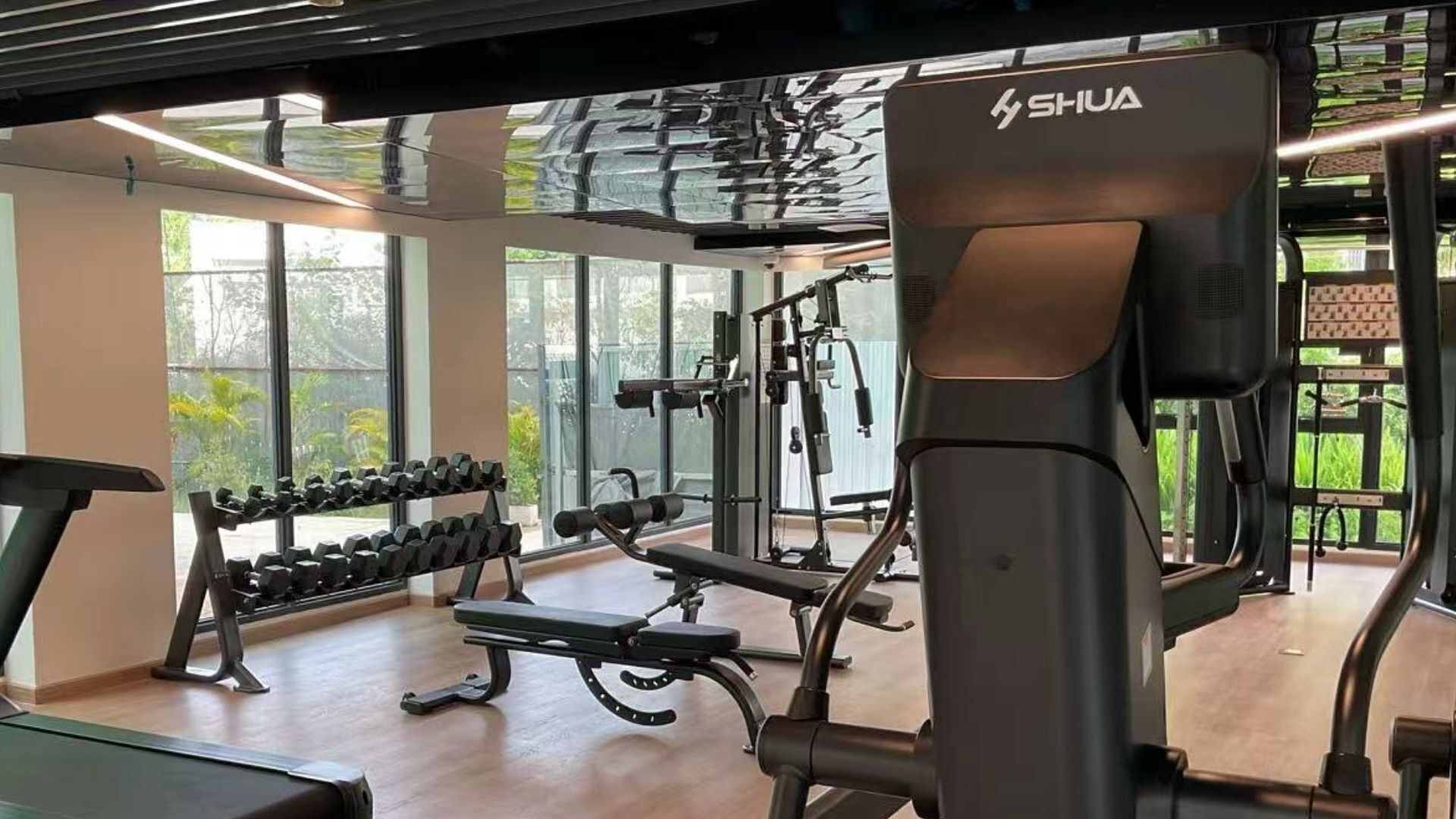 Une salle de sport équipée de matériel d’exercice, d’un tapis de course et d’haltères.