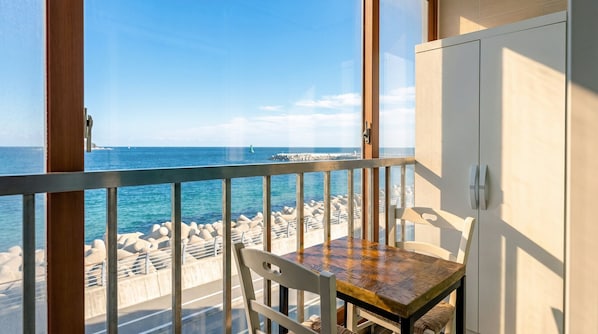 Un balcone con vista sul mare, un tavolo e una sedia.