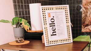 A wooden shelf with magazines, a framed note, and a potted plant. - Designer Inspired Cozy Abode in the Heart of Cebu City (Cebu City)