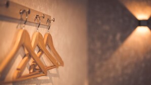 Un porte-manteaux mural en bois, doté de plusieurs crochets.