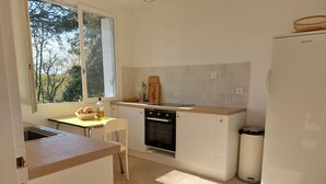 A compact kitchen with a window, a sink, a stove, and a refrigerator. - Secluded vineyard with jacuzzi (Beaulieu-sur-Loire)