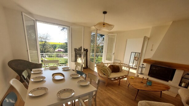 A spacious living room with a dining area, large windows, and a fireplace. - Secluded vineyard with jacuzzi (Beaulieu-sur-Loire)