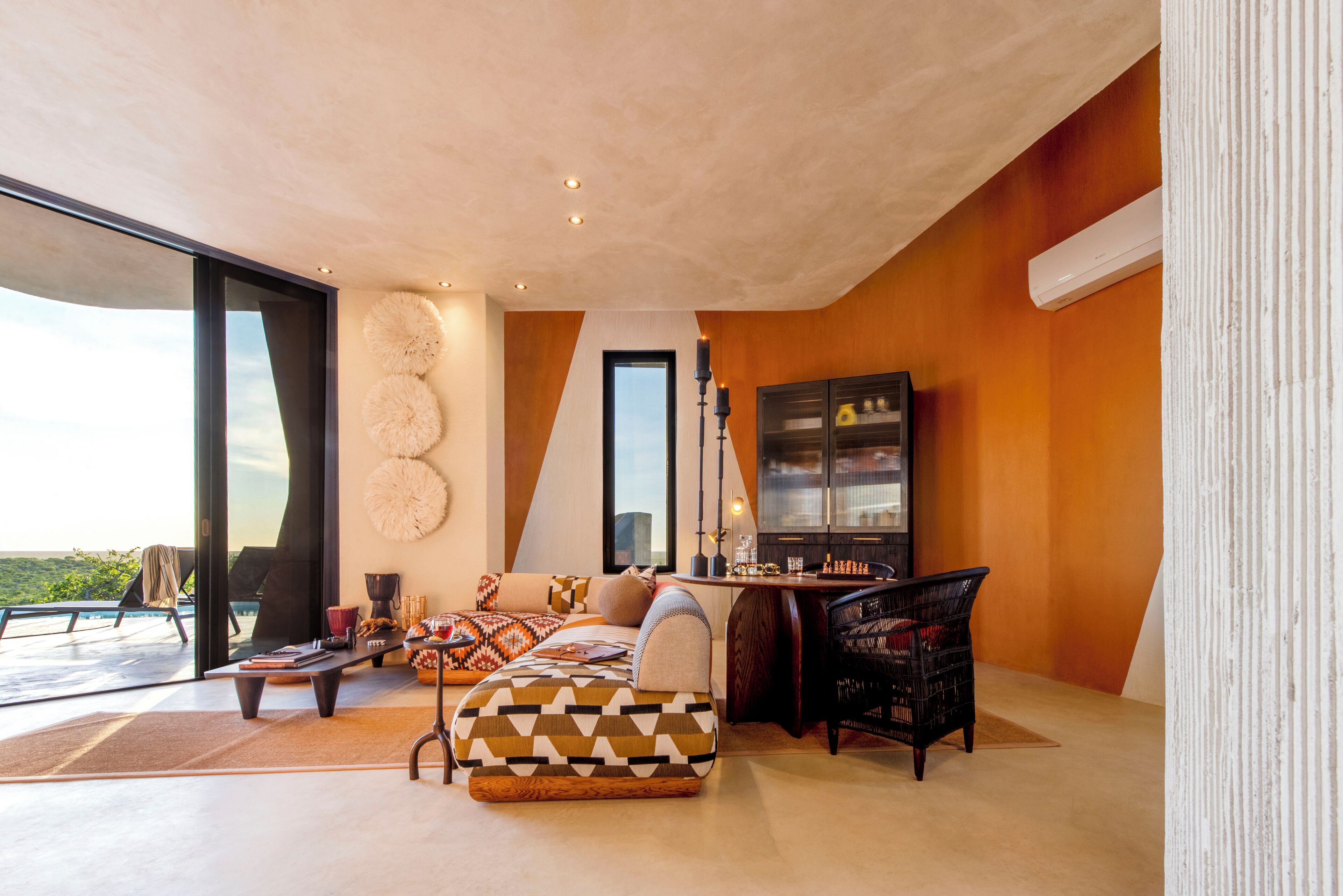 Una sala de estar moderna con un ventanal grande, un sofá, una mesa de centro y una estantería.