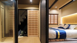 Une chambre d’hôtel moderne avec un grand lit, une porte coulissante et un escalier.