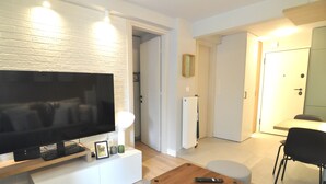 A living room with a flat-screen TV, a coffee table, and a seating area. - Zennova 71 Mondè Thessaloniki Apt (Thessaloniki)