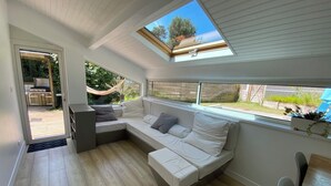 A modern living room with a large sectional sofa, a small table, and a skylight. - Villa 71 Hossegor with heated pool, basketball, pétanque and vacation atmosphere (Soorts-Hossegor)