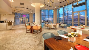 A spacious hotel lobby with marble flooring, multiple dining areas, and large windows offering city views. - Hangzhou Binjiang Baolong Juntels (Hangzhou)