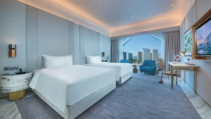 A hotel room with two beds, a desk, and a chair. There is a city view through the window. - Hangzhou Binjiang Baolong Juntels (Hangzhou)