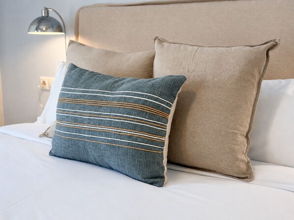 A bed with two pillows, one with a striped pattern and the other plain. - Stay U-nique Apartments Balmes II (Barcelona)