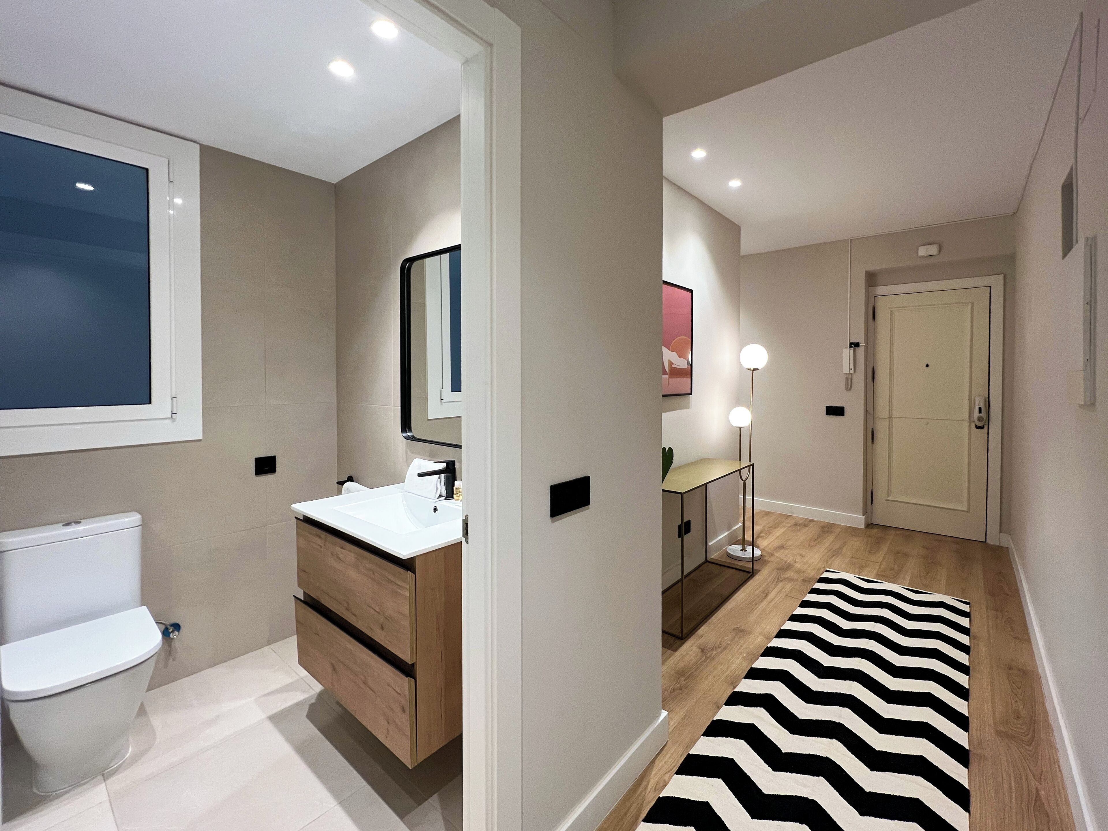 A modern bathroom with a toilet, sink, and vanity.